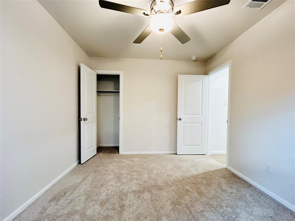 2505 McNally Drive Mesquite, TX 75181 - Photo 19 of 28 an empty room with a chandelier fan and windows