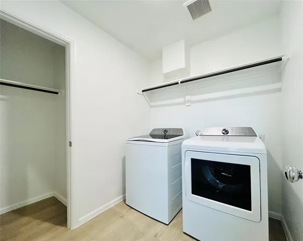 a view of washer and dryer with kitchen in the background