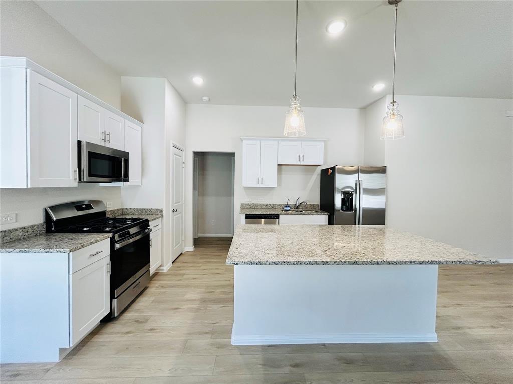 2505 McNally Drive Mesquite, TX 75181 - Photo 6 of 28 a large kitchen with granite countertop a stove top oven a sink a counter space and cabinets