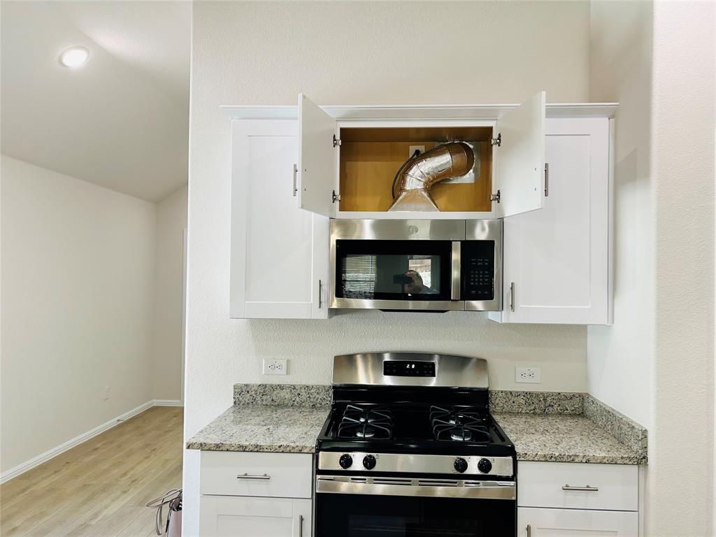 2505 McNally Drive Mesquite, TX 75181 - Photo 8 of 28 a kitchen with stainless steel appliances granite countertop a stove a microwave and oven