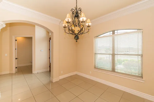 a view of a room with a chandelier and large windows