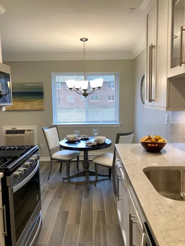 a kitchen with a stove a sink a dining table and chairs
