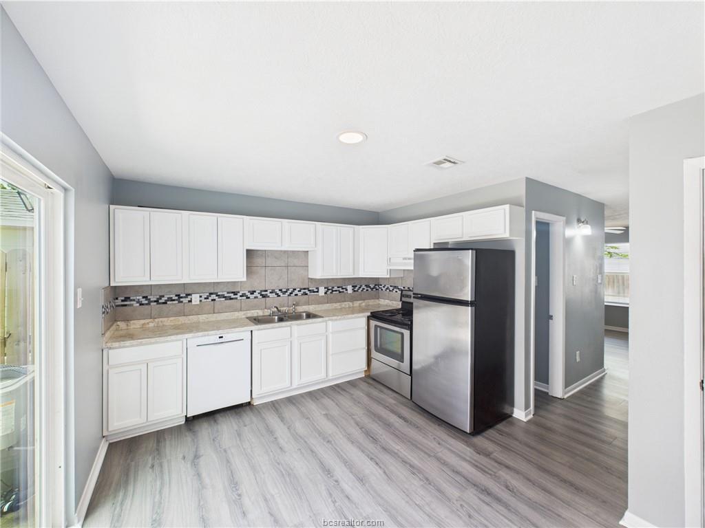1104 Verde Drive, Unit A Bryan, TX 77801 - Photo 4 of 11 a kitchen with stainless steel appliances a refrigerator sink and stove