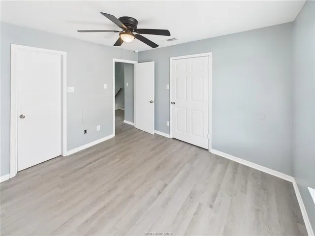 an empty room with window and a ceiling fan