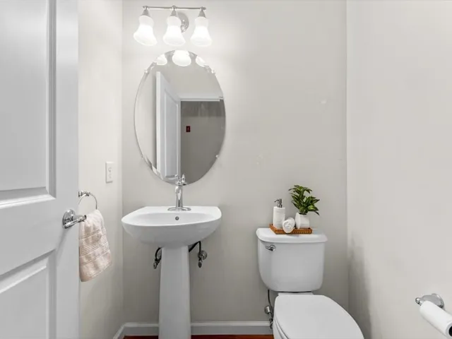 a bathroom with a toilet a sink and mirror