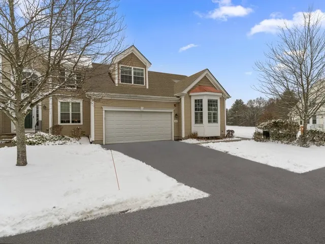 a front view of a house with a yard covered in snow