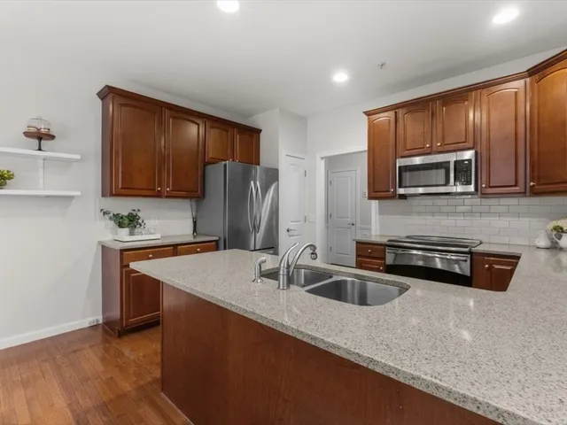 a kitchen with stainless steel appliances granite countertop a sink refrigerator and microwave