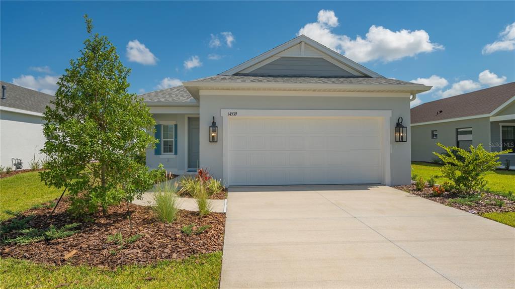 14539 Skipping Stone Loop Parrish, FL 34219 - Photo 1 of 1 a front view of a house with a yard and a garden