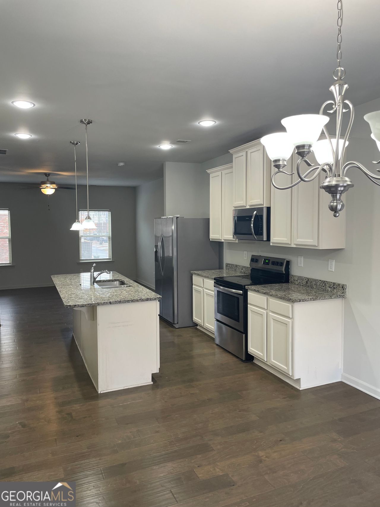 3810 Equity Lane Powder Springs, GA 30127 - Photo 12 of 32 a kitchen with stainless steel appliances granite countertop a sink a stove a refrigerator and white cabinets