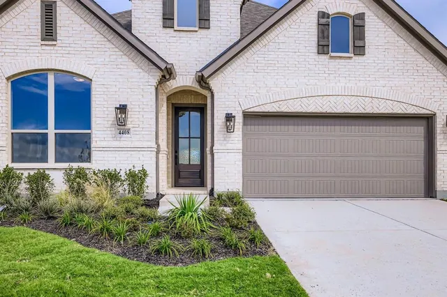an empty room with wooden floor fireplace and windows