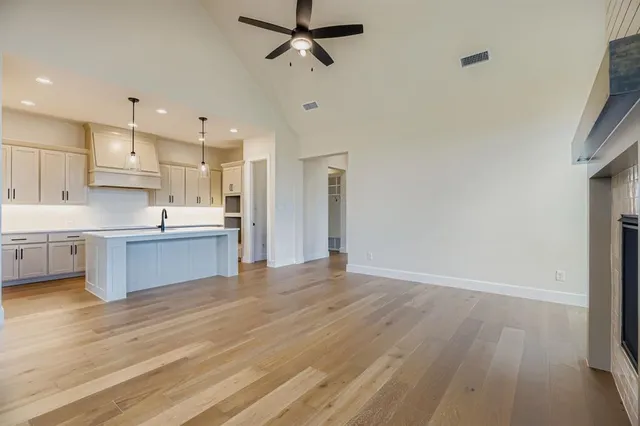 a kitchen with white cabinets appliances and wooden floor