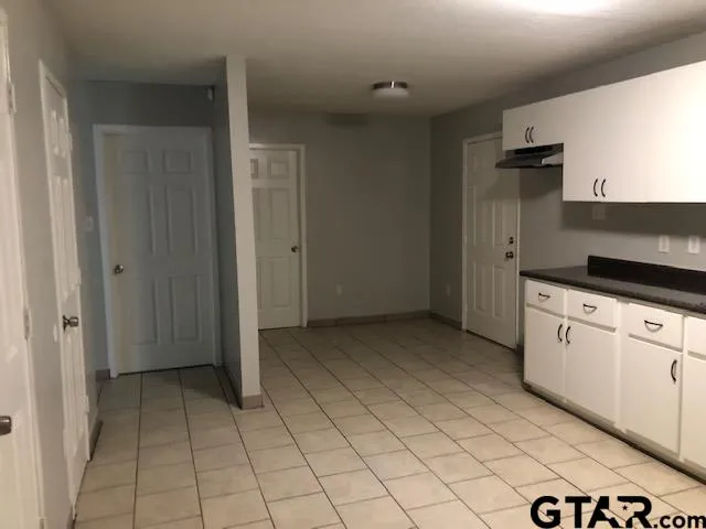 a view of a kitchen with white cabinets