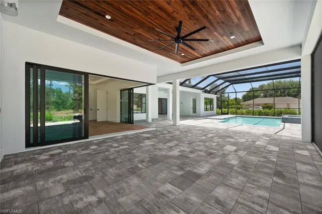 a living room with patio furniture and a floor to ceiling window