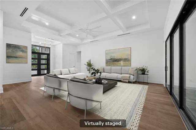 a view of an empty room with glass door and chandelier fan