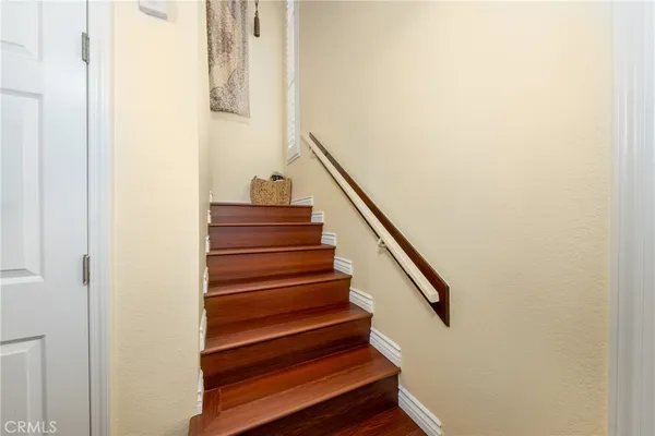 a view of a hallway with wooden floor and chandelier