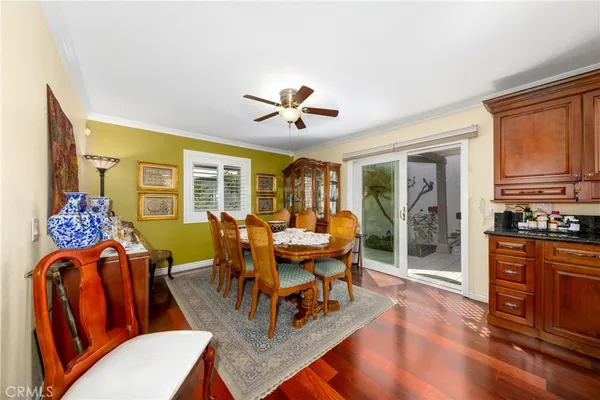 a living room with wooden floors and a dining table
