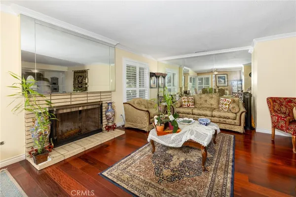 a living room with furniture large window and wooden floor