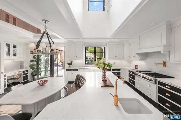 a kitchen with stainless steel appliances kitchen island granite countertop a stove a sink a dining table and chairs