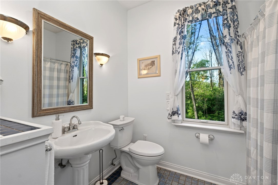 330 South Alpha Bellbrook Road Bellbrook, OH 45305 - Photo 23 of 87 This serene bathroom offers a bright and airy atmosphere, with a charming window overlooking lush greenery.
