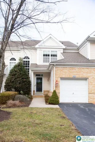 a view of a white house with a large tree and a yard with side of it