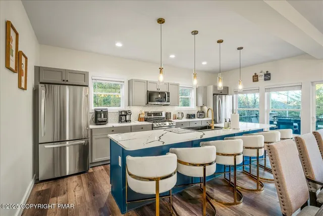 a kitchen with stainless steel appliances kitchen island a white stove top oven and refrigerator
