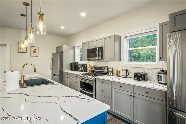 a spacious bedroom with a large bed chandelier and a window