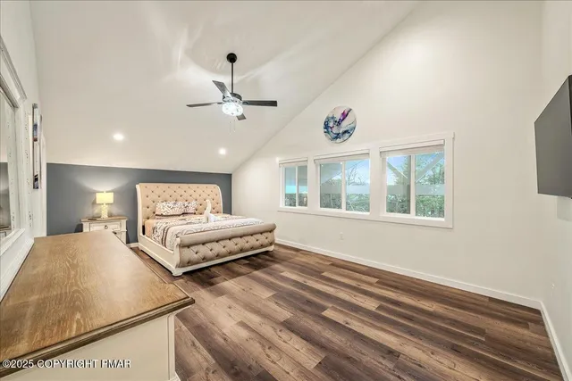 a bedroom with a bed a window and flat screen tv