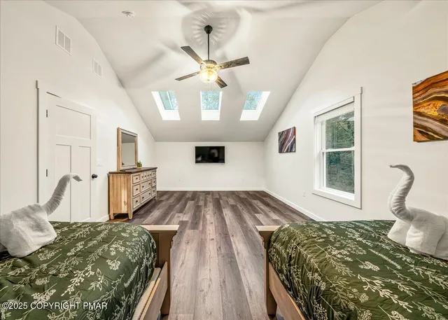 a view of a hallway to a livingroom with wooden floor and entryway
