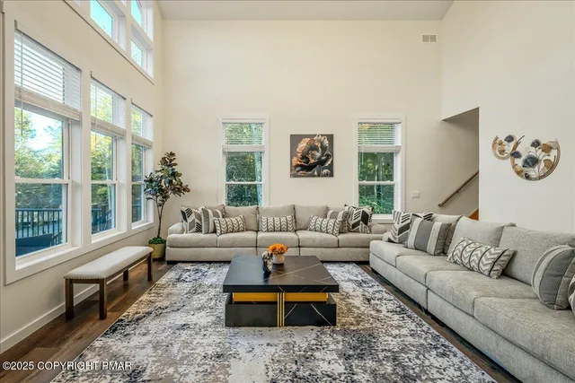 a kitchen with stainless steel appliances kitchen island granite countertop a stove a sink a dining table and chairs with wooden floor