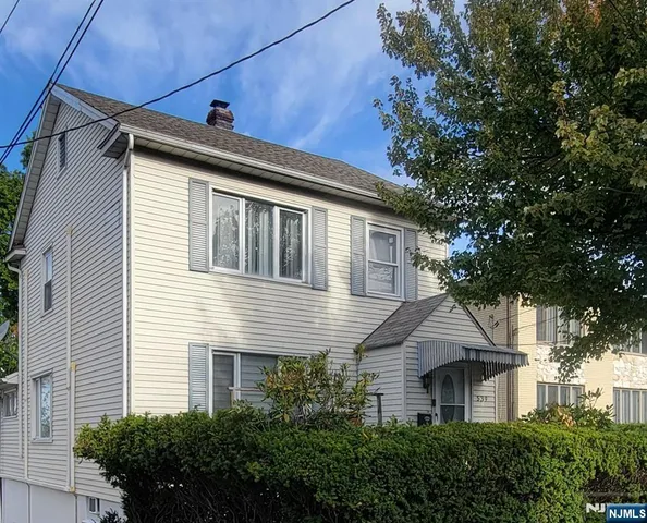 a front view of a house with a yard and potted plants