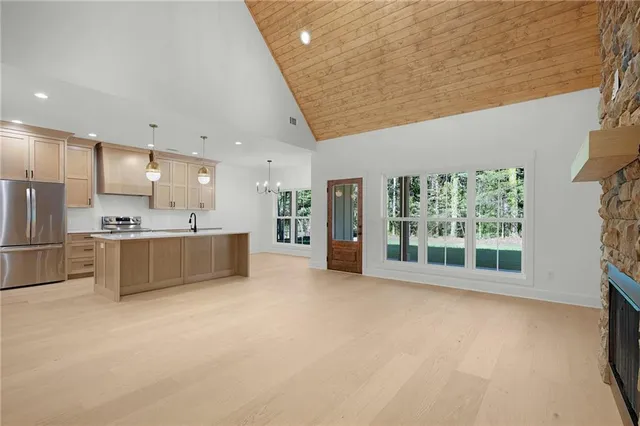 a large kitchen with stainless steel appliances wooden cabinets a sink and a large window