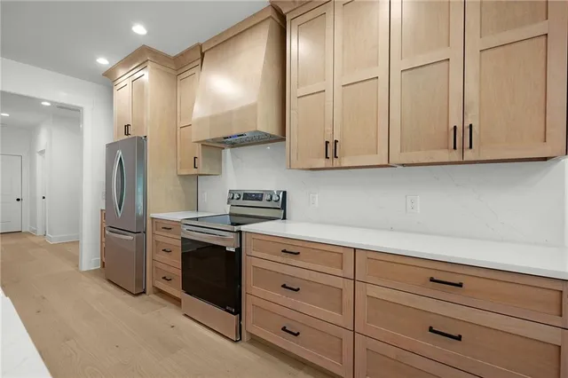 a kitchen with stainless steel appliances granite countertop a refrigerator and a stove top oven