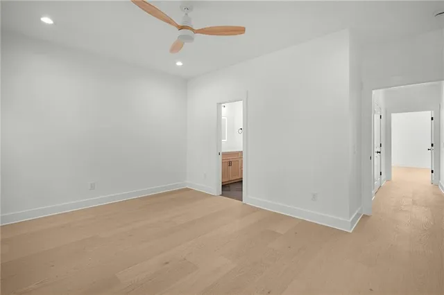 an empty room with an entryway and fan