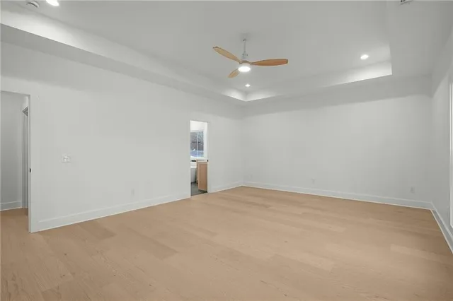 an empty room with a ceiling fan and window