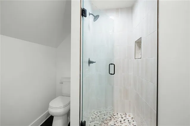 a bathroom with a shower a toilet and a shower