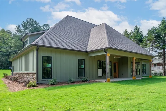 a view of a brick house with a yard potted plants and a table