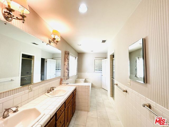 a bathroom with a sink a mirror and a bathtub