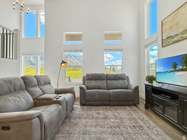 641 Desert Willow Drive Mapleton, UT 84664 - Photo 8 of 41 Living room featuring a high ceiling, wood finished floors, healthy amount of natural light, and hanging lights