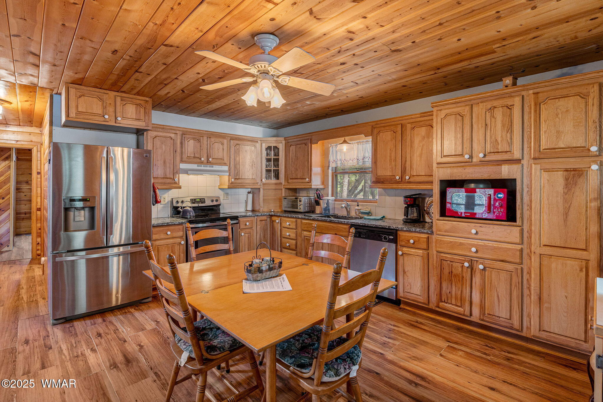 2933 Wildcat Trail Overgaard, AZ 85933 - Photo 12 of 44 a kitchen with stainless steel appliances granite countertop a refrigerator a sink dishwasher a stove and white countertops with wooden floor