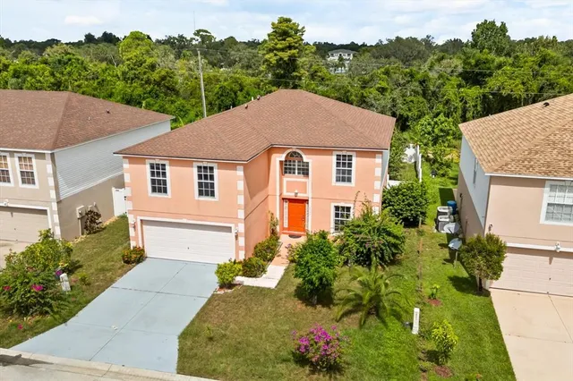 a view of a white house with a yard and potted plants