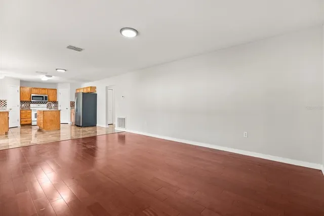 a view of an empty room with wooden floor