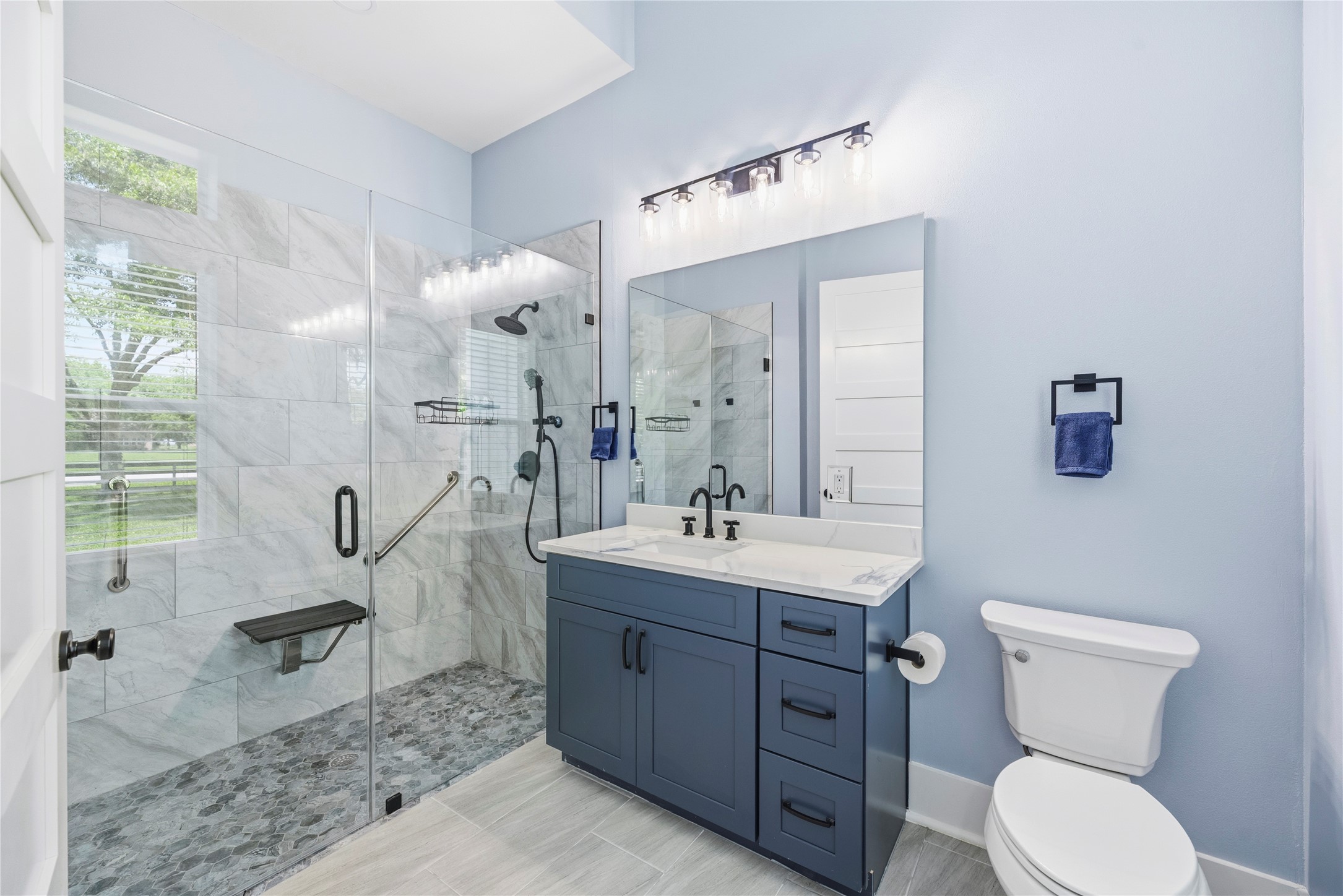 4607 Clayhead Road Richmond, TX 77406 - Photo 20 of 49 Designer guest bath featuring a frameless walk-in shower, marble-look finishes, and sleek modern fixtures.