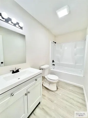 a bathroom with a toilet sink a mirror and shower
