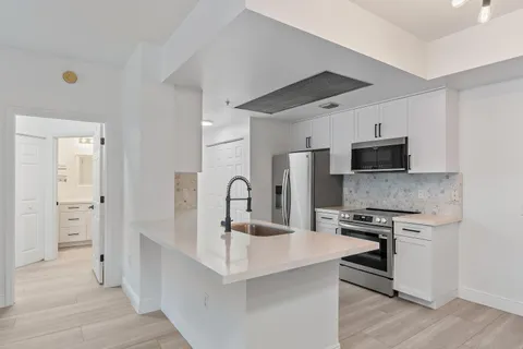 a kitchen with stainless steel appliances a sink stove and refrigerator