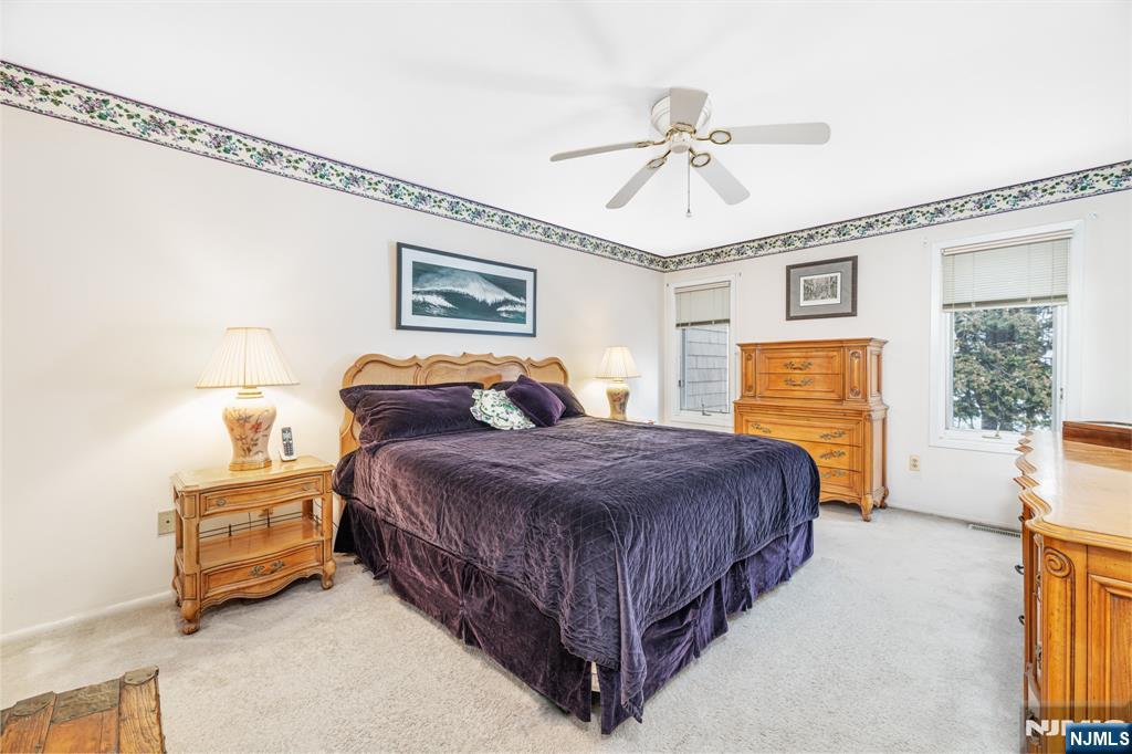 44 Mill Pond Road Little Falls, NJ 07424 - Photo 23 of 37 a bedroom with a bed and a chandelier