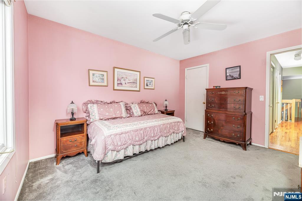 44 Mill Pond Road Little Falls, NJ 07424 - Photo 29 of 37 a spacious bedroom with a bed and a chandelier