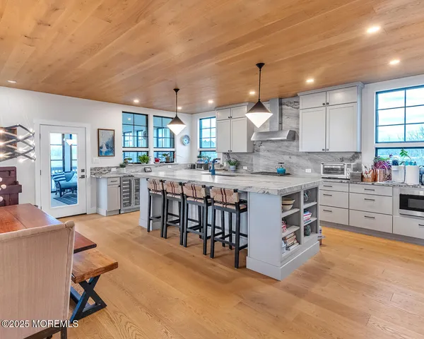 a large kitchen with kitchen island a stove a sink a dining table and chairs