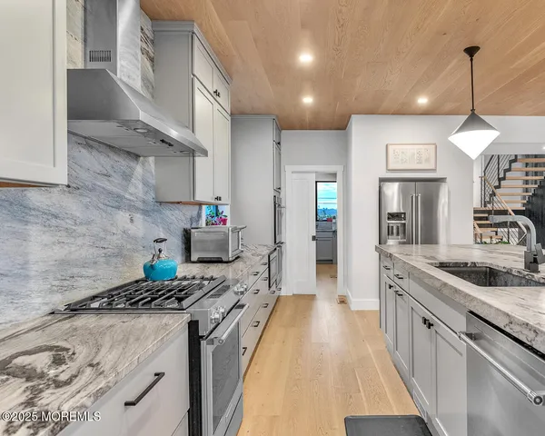 a kitchen with stainless steel appliances granite countertop a sink stove and refrigerator