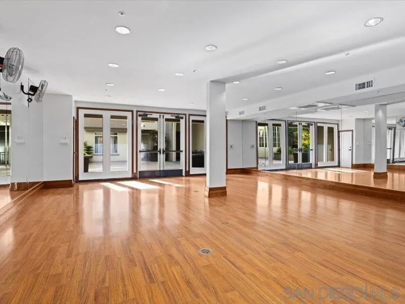9237 Regents Road, Unit K101 La Jolla, CA 92037 - Photo 21 of 29 an empty room with wooden floor and large windows
