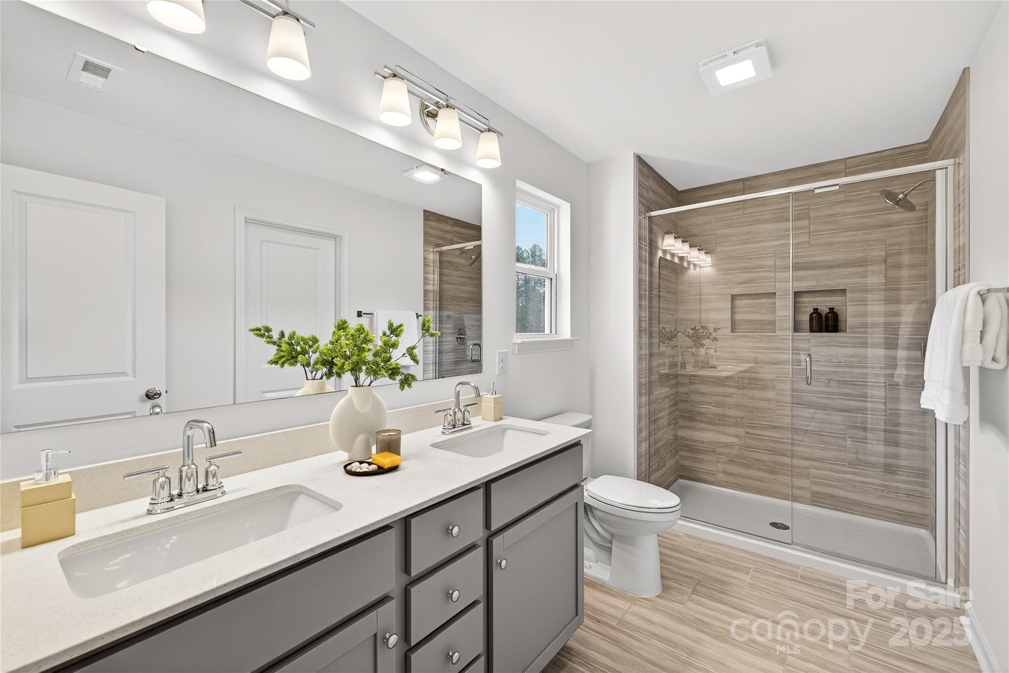10423 Lakeshore Drive, Unit 71 Lancaster, SC 29720 - Photo 21 of 31 a bathroom with a double vanity sink toilet and shower